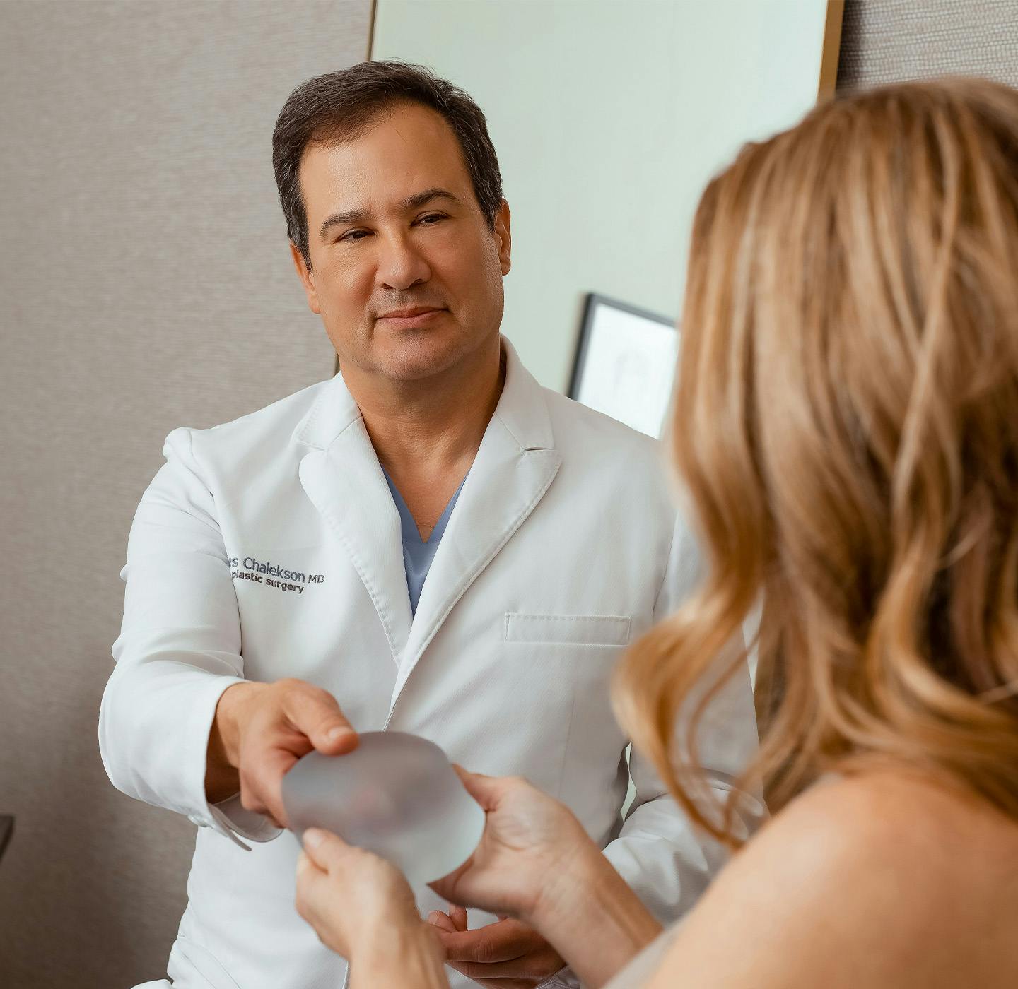 Doctor handing patient implant