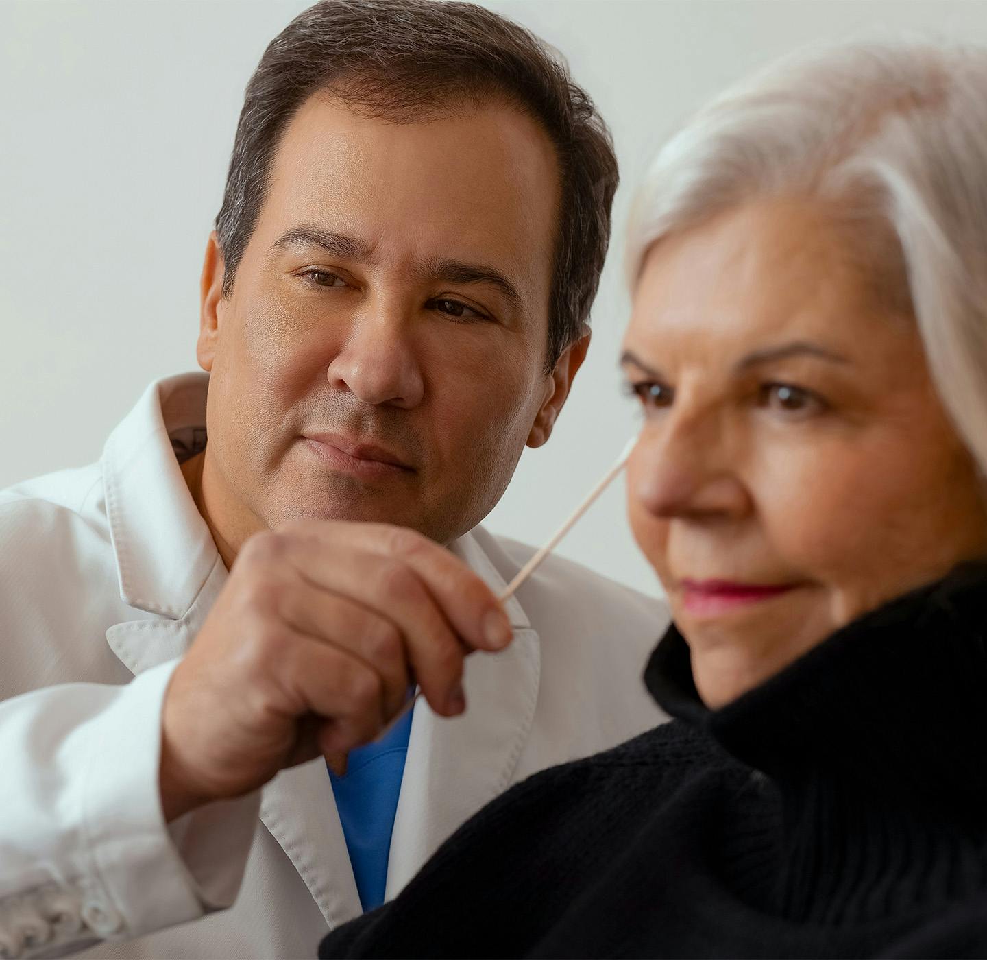 doctor pointing to a patient's face with a q-tip