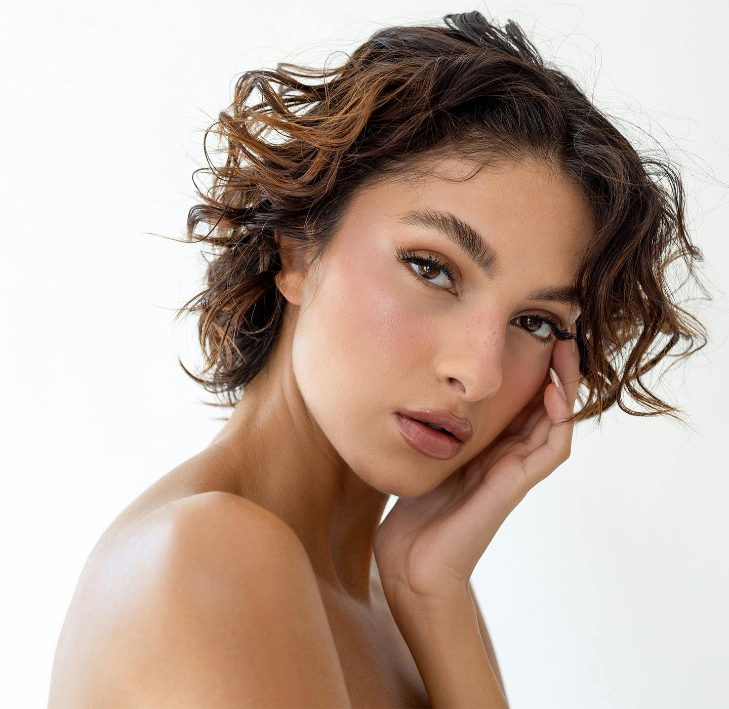 woman leaning her face onto her hand
