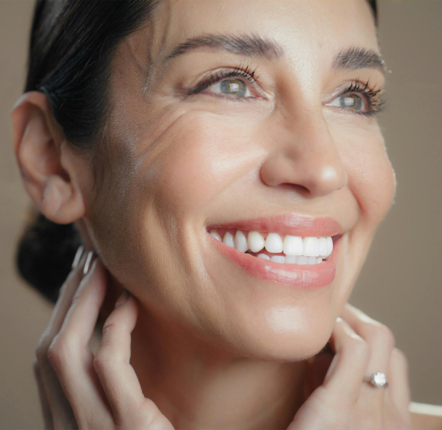 Women smiling hands on face