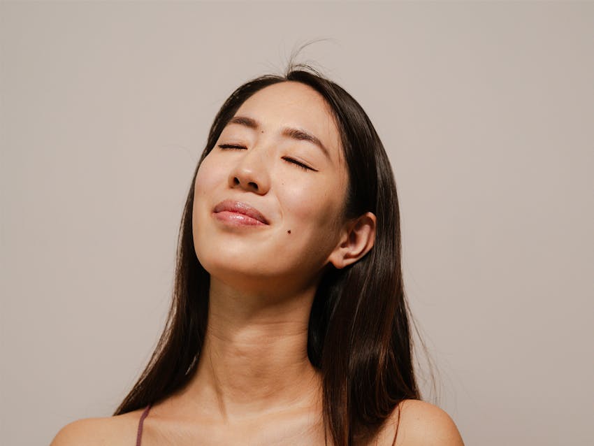woman closing her eyes and smiling