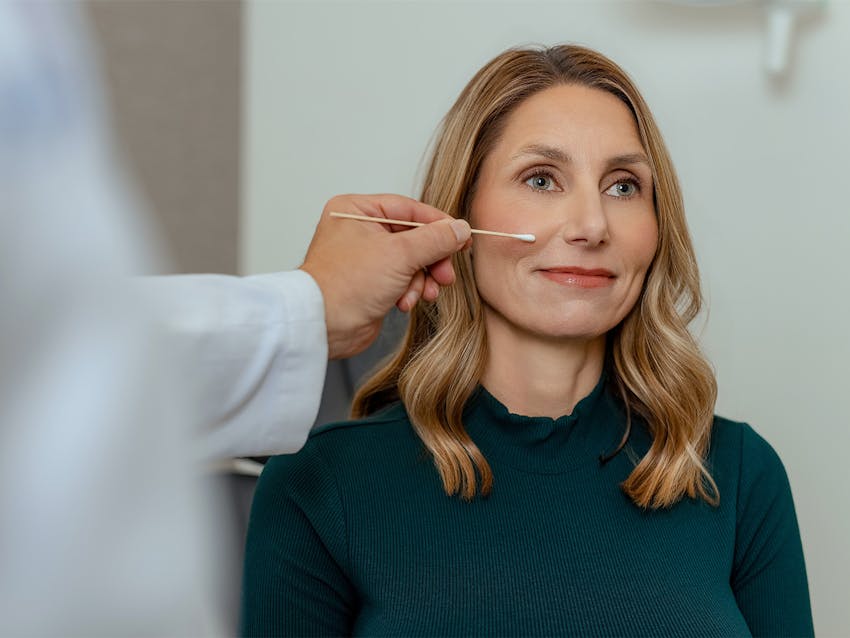 doctor pointing to a patient's face with a q-tip