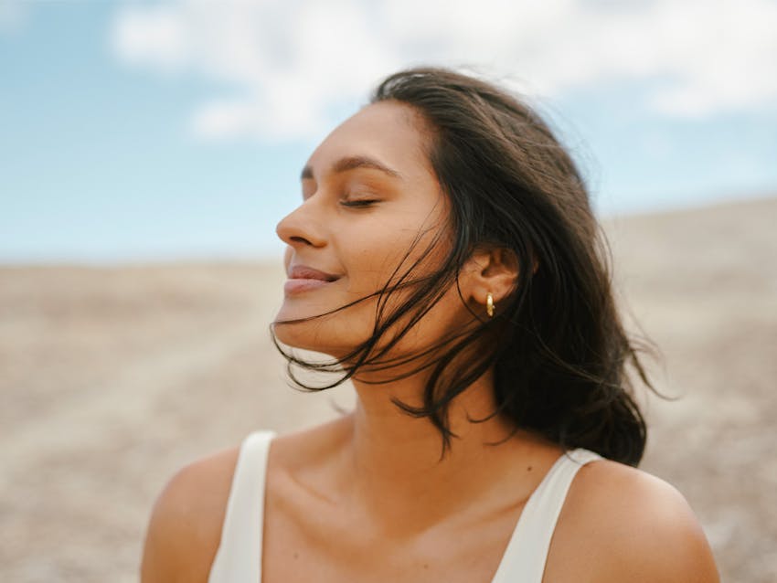 woman closing her eyes and smiling
