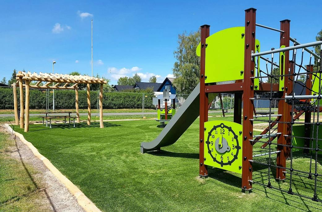 Kommunal lekplats i Askersund med lekställning, rutschkana, pergola och konstgräs