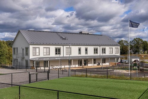Skolgård på JENSEN grundskola med konstgräs och staket