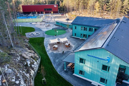 Förskolegård på Raoul Wallenbergskolan med sandlek, lekhus och solsegel