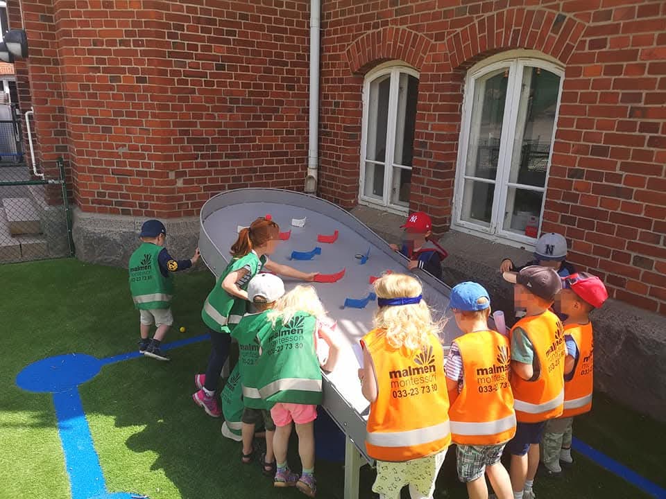 Förskolebarn samlade runt ett Pinpoint på skolgården