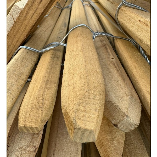 Närbild på sågade och spetsade spjälor i robinia, sammanfogade med tvinnad ståltråd till ett rullstaket