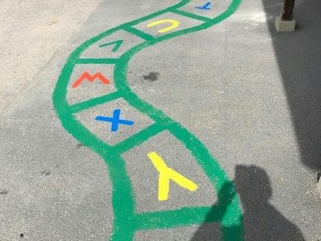 Slingrande bokstavsbana målad i grönt med bokstaven i varje ruta