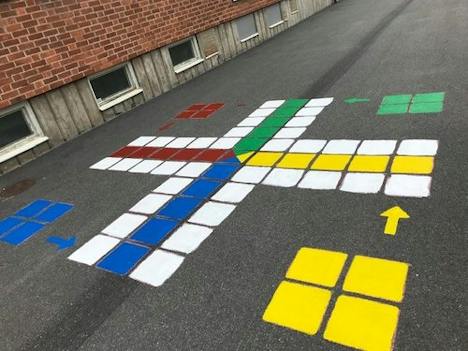 Fiaspel i rött, gult, grönt och blått målat på asfalt