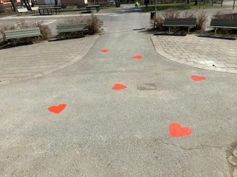 Röda hjärtan målade på en gångväg i en park