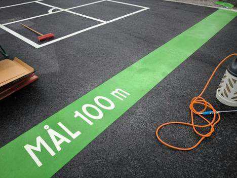 Grön mållinje märkt MÅL 100 m under applicering