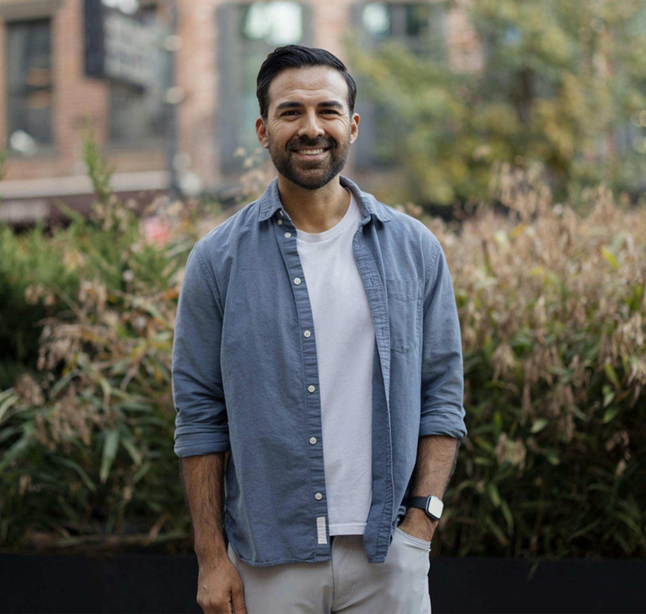 man in a white shirt and blue overshirt