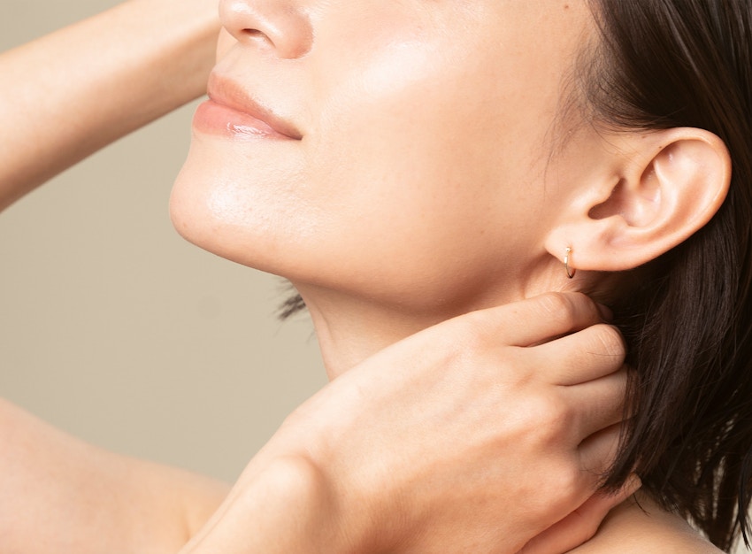 woman touching her face and neck