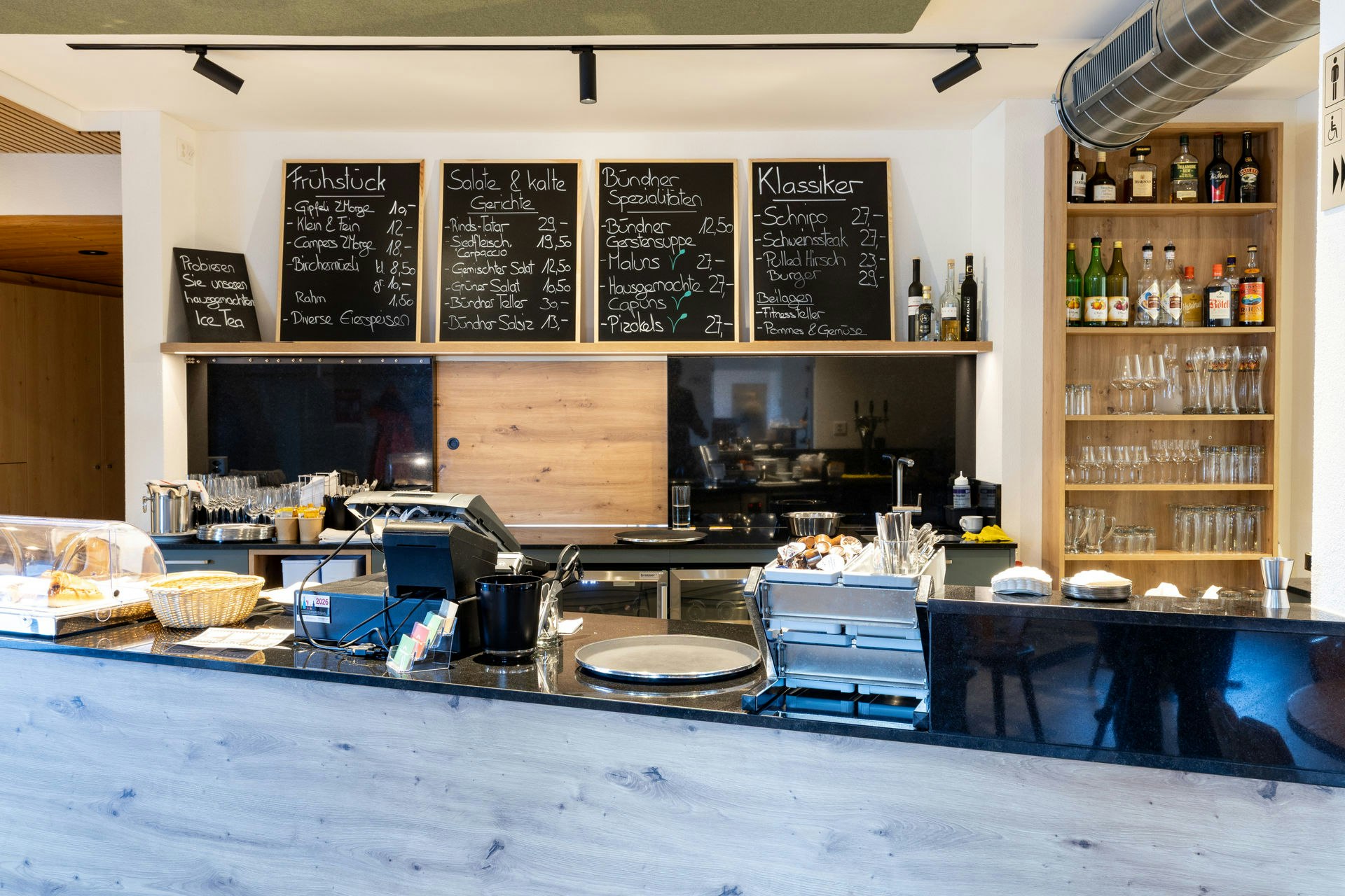 Theke mit Kaffeemaschine und Menütafeln im Restaurant
