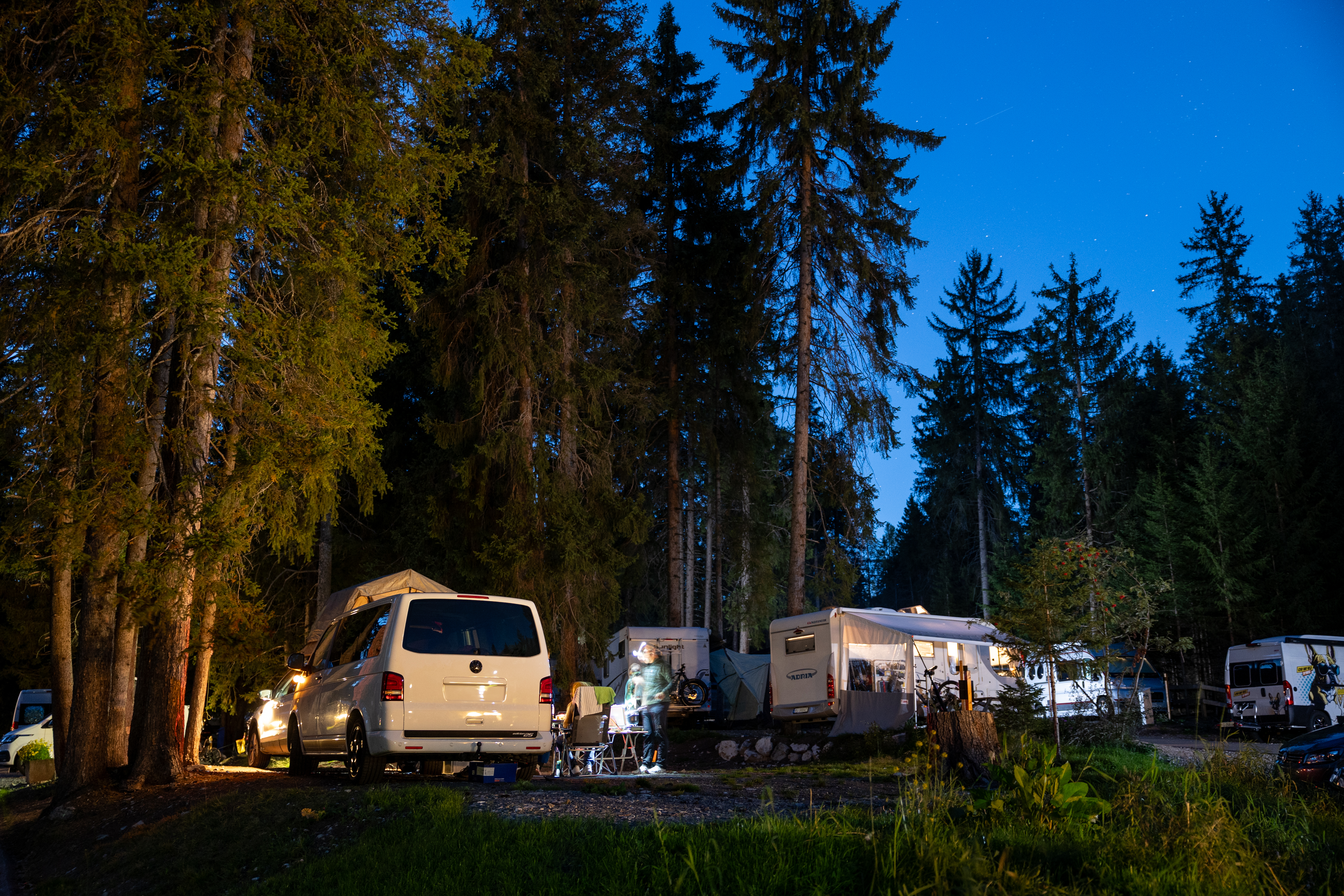 Wohnmobile zwischen Bäumen bei Nacht mit Sternenhimmel, Camping Gravas