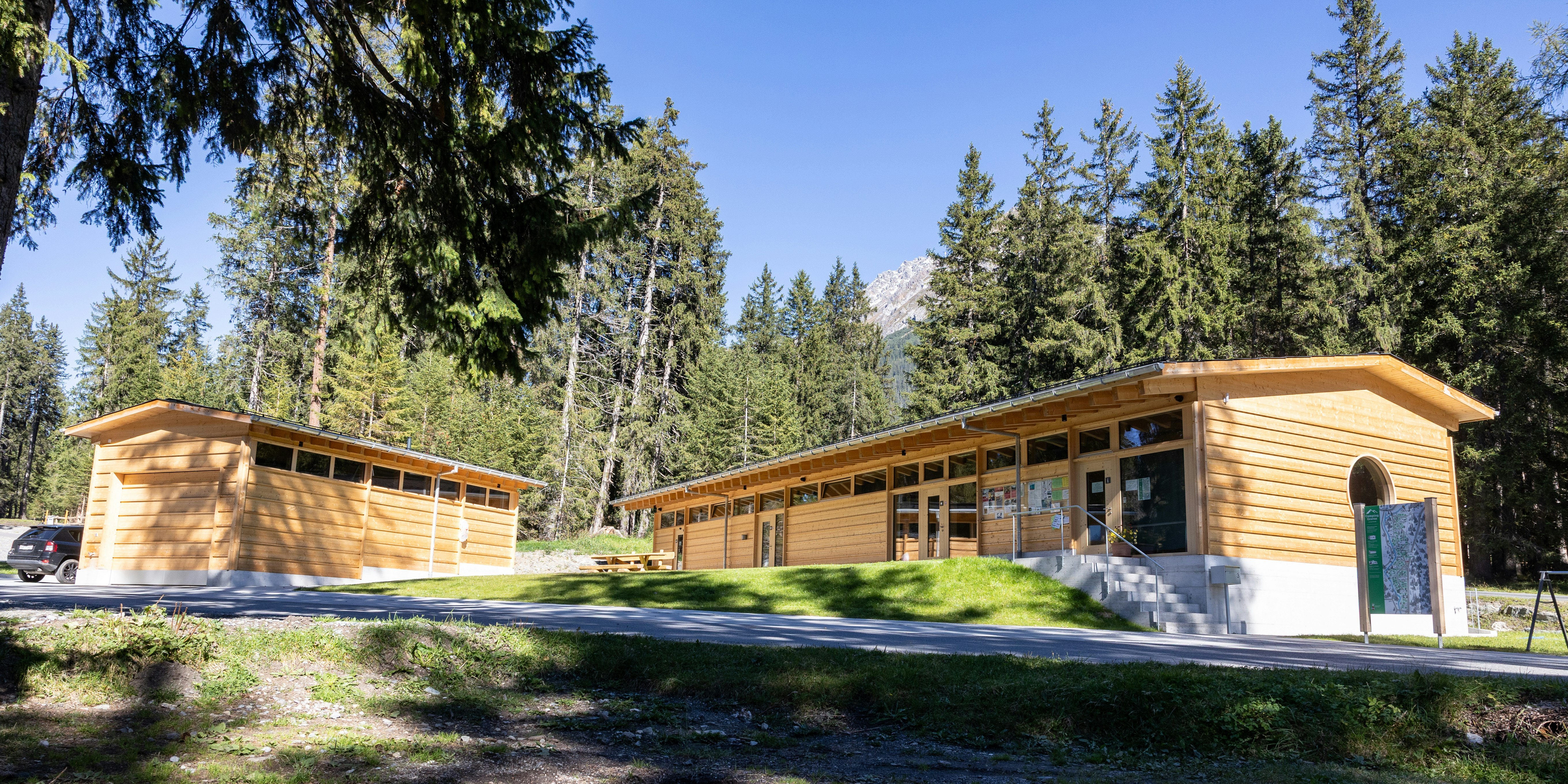 Empfangsgebäude Gravas Holzgebäude mit Zufahrtsweg im Sonnenlicht, Camping Gravas