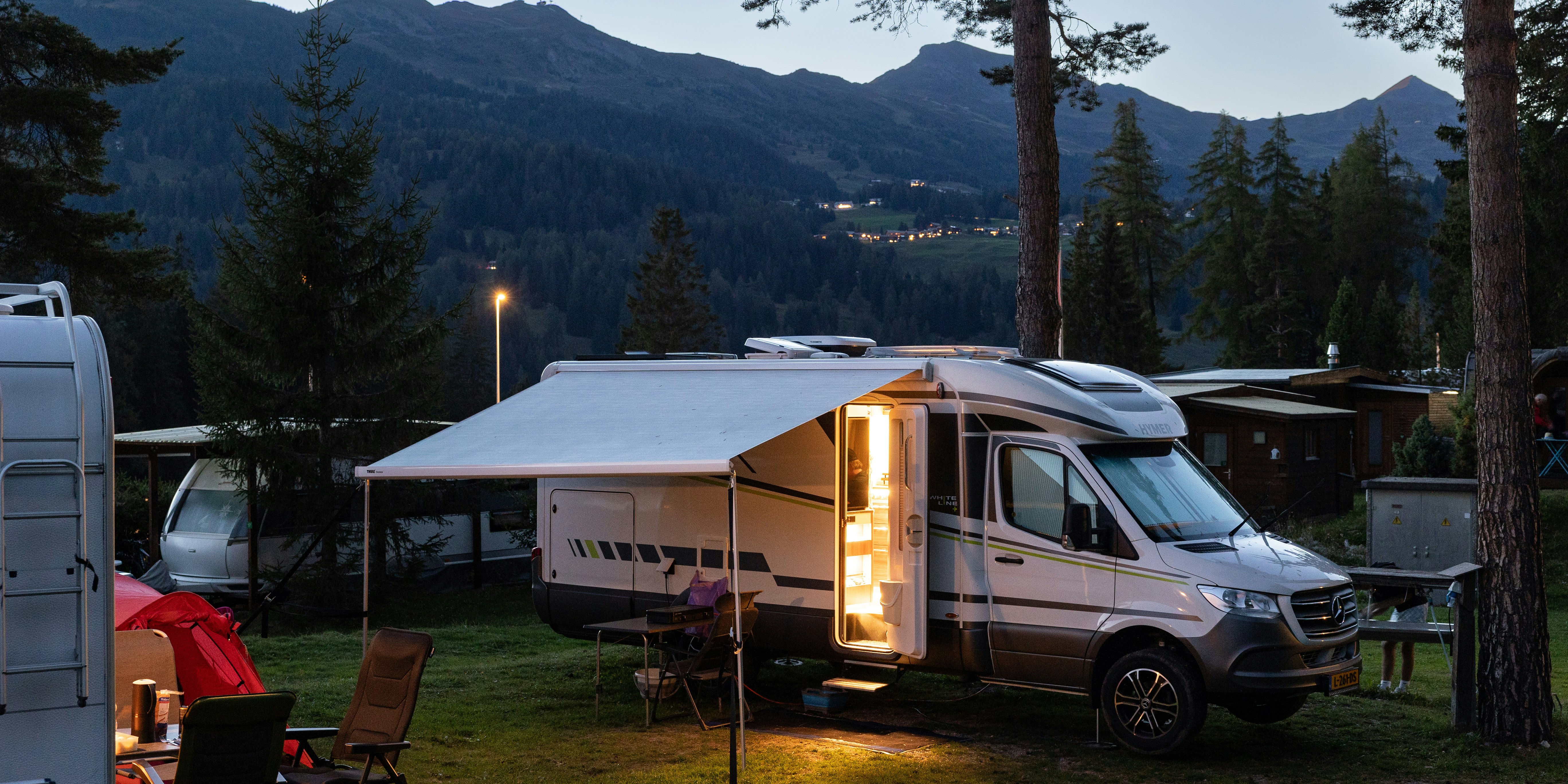 Wohnmobile im Abendlicht Wohnmobile zwischen Bäumen im warmen Abendlicht, Camping St. Cassian