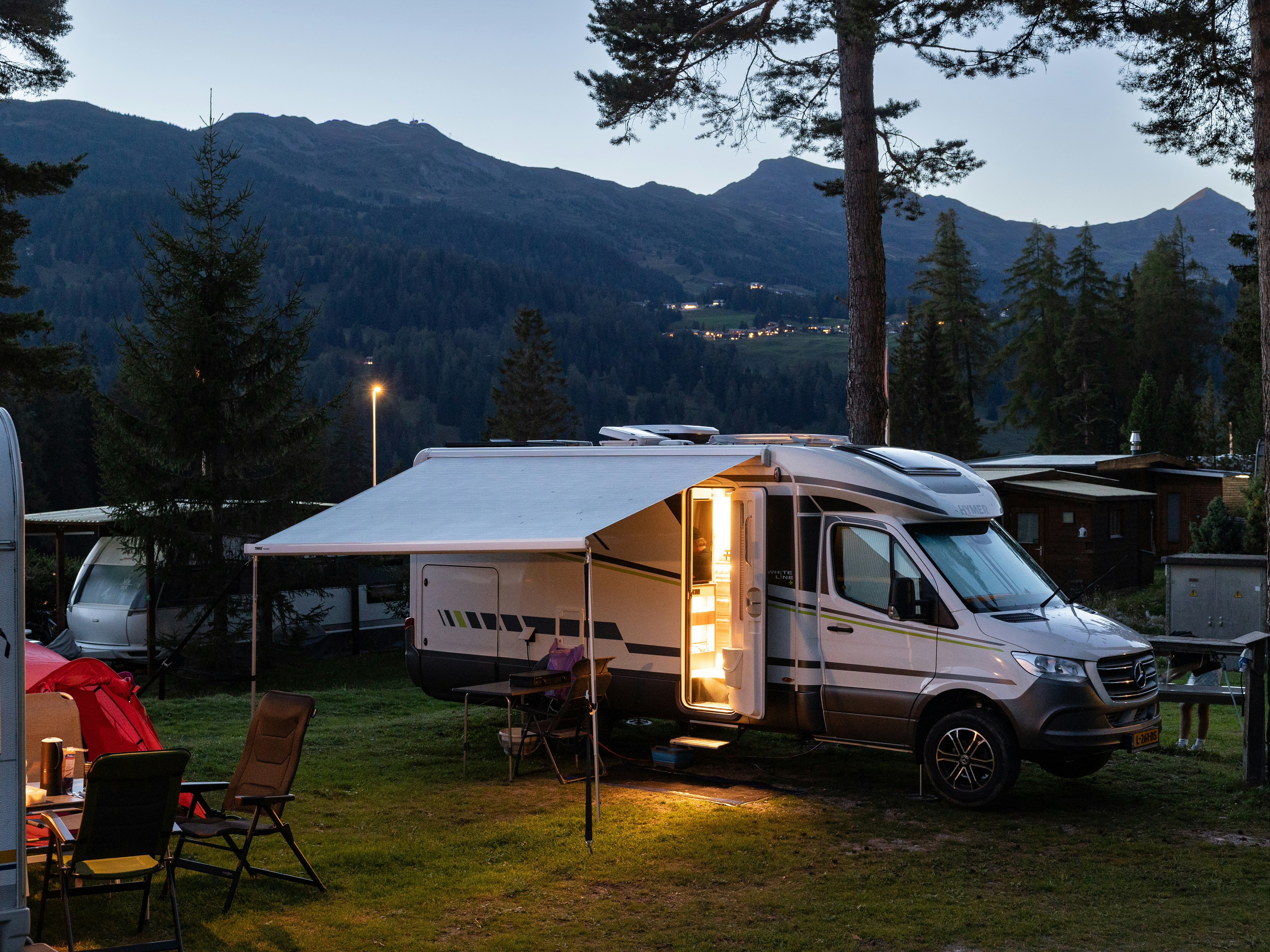 Wohnmobile im Abendlicht Wohnmobile zwischen Bäumen im warmen Abendlicht, Camping St. Cassian