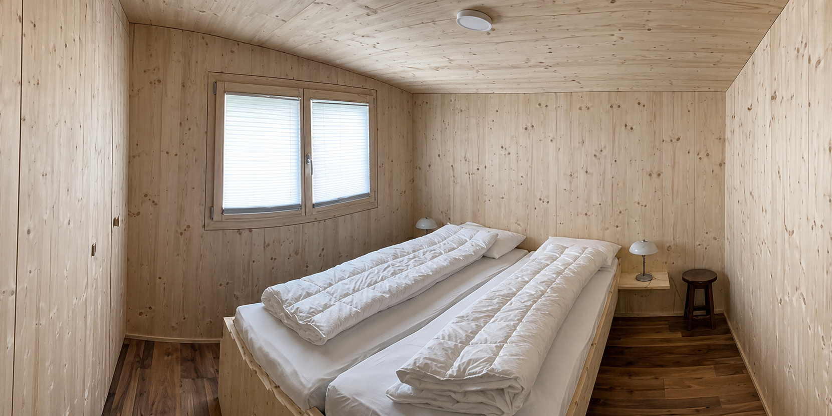 Chalet Innenansicht Gemütliches Zimmer mit Bett direkt am Fenster