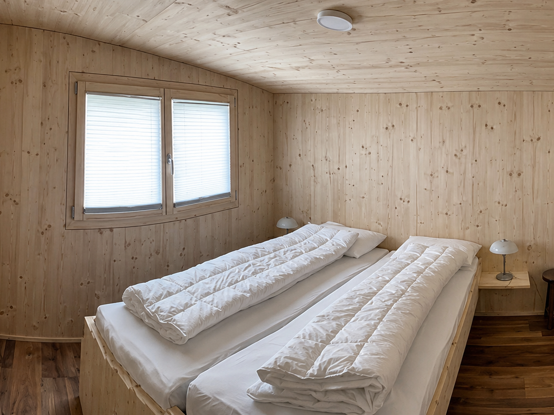 Chalet Innenansicht Gemütliches Zimmer mit Bett direkt am Fenster