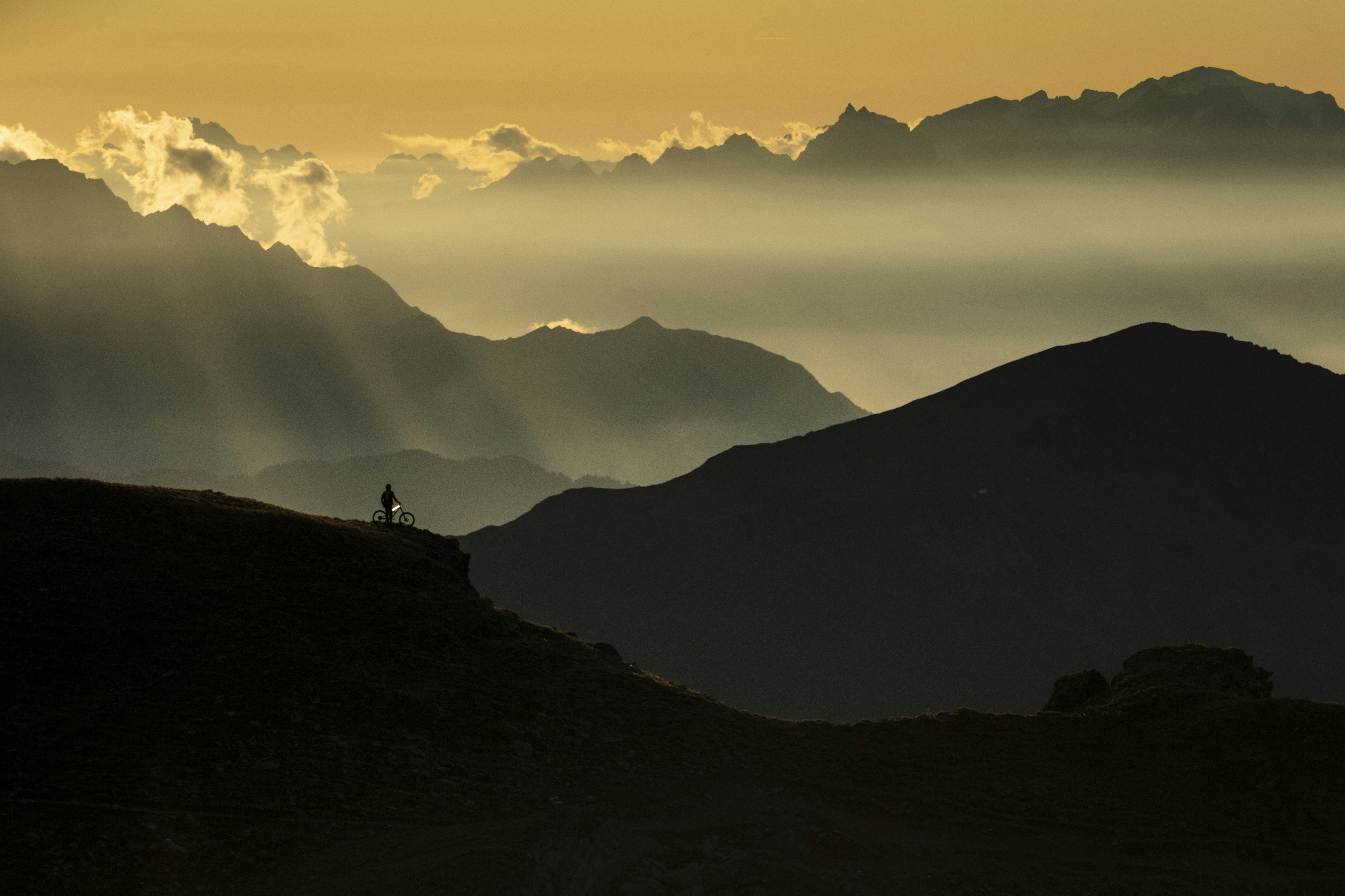 Dunkle Bergsilhouette vor farbigem Abendhimmel