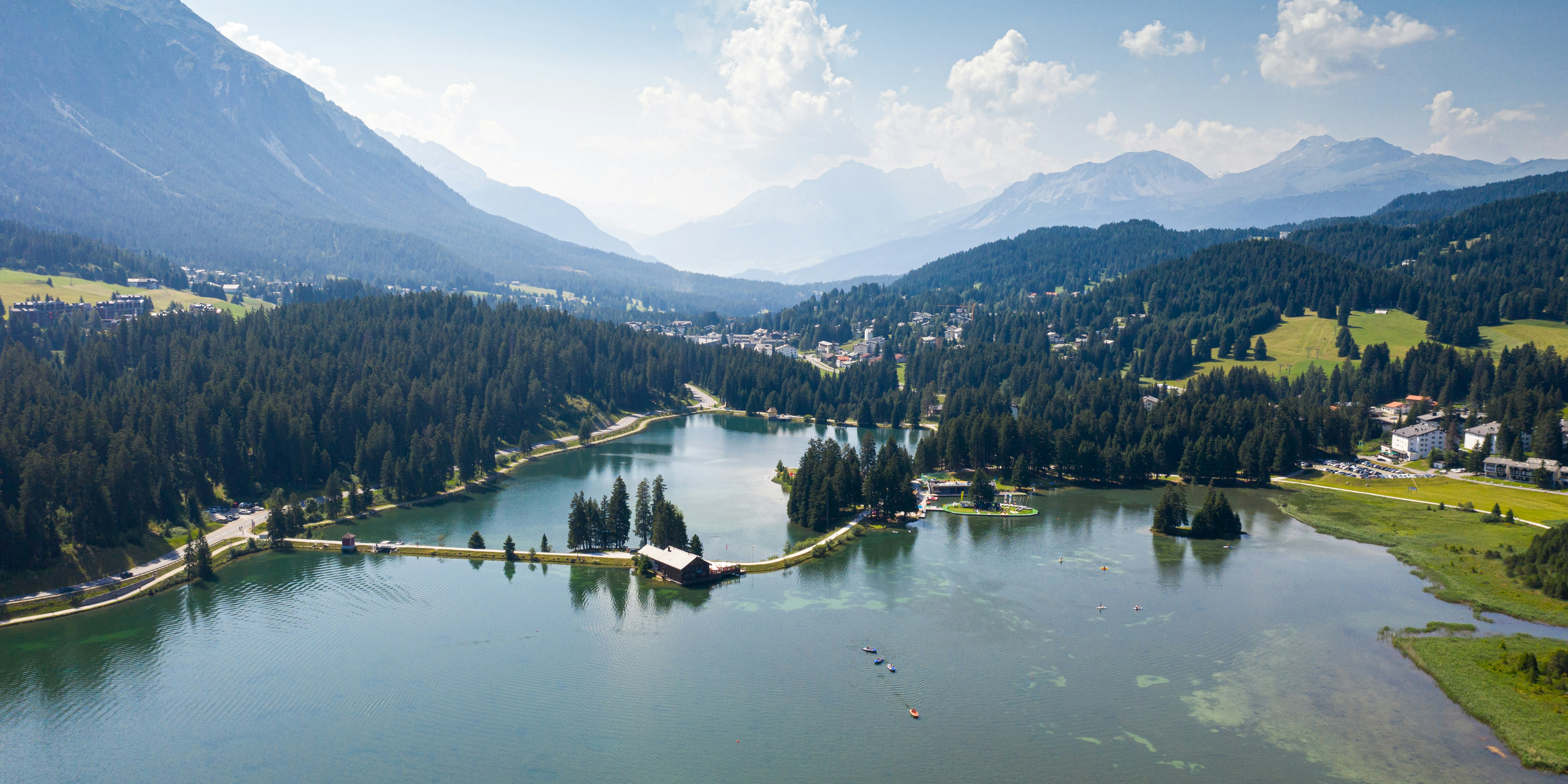 Heidsee Lenzerheide See mit Spiegelung der umliegenden Berge und Wälder