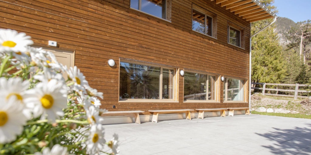 Ferienhaus mit Blumen Ferienhaus mit blühenden weissen Blumen vor dem Eingang