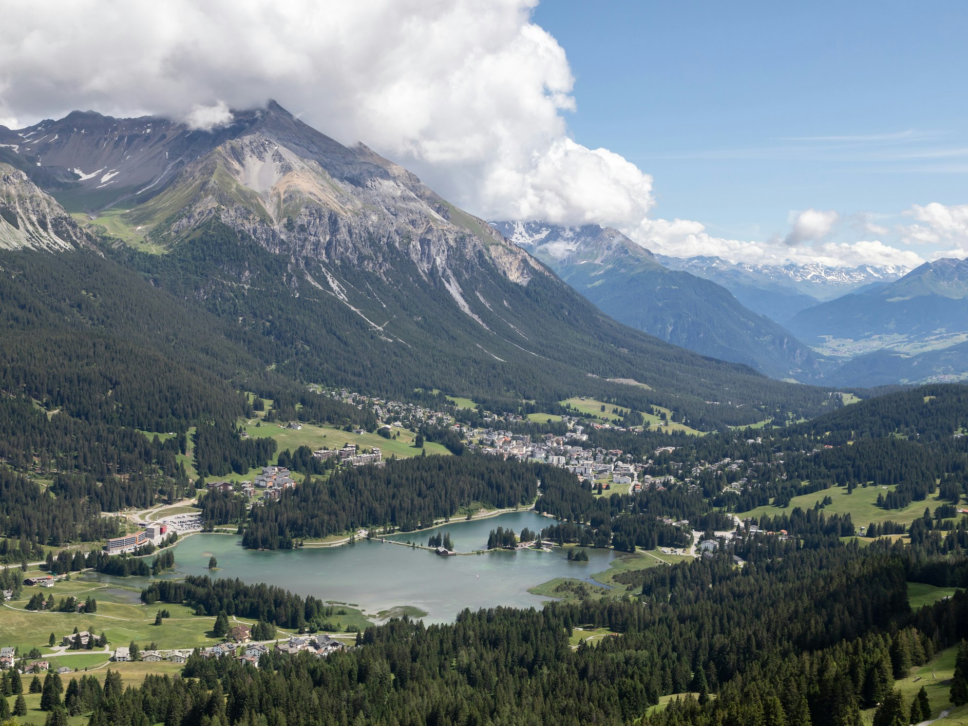 Heidsee Lenzerheide Türkisfarbener Bergsee umgeben von grünen Wäldern und Gipfeln