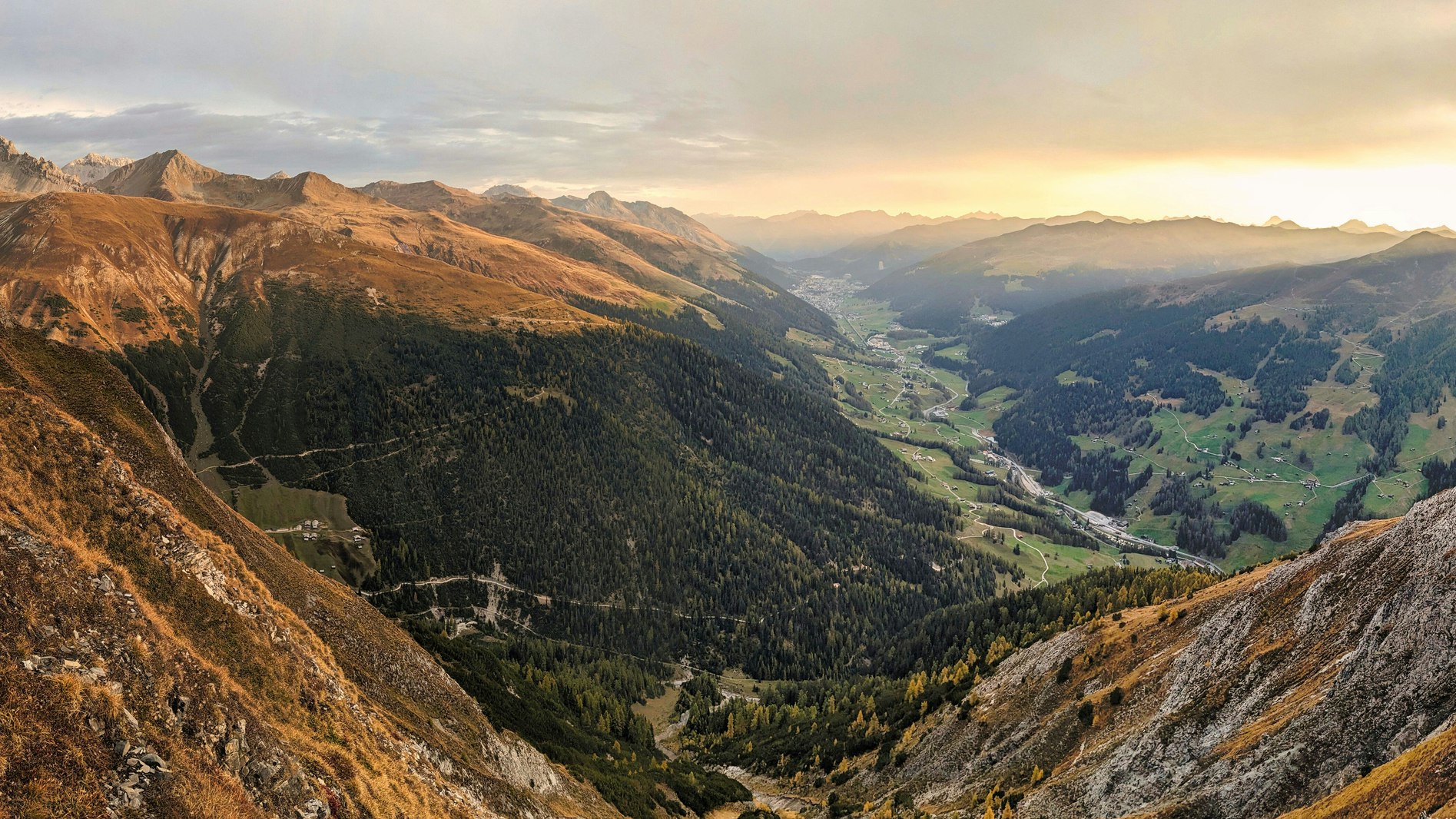 Bergpanorama Lenzerheide Bergtal in warmem Abendlicht mit Nebelschwaden über den Gipfeln