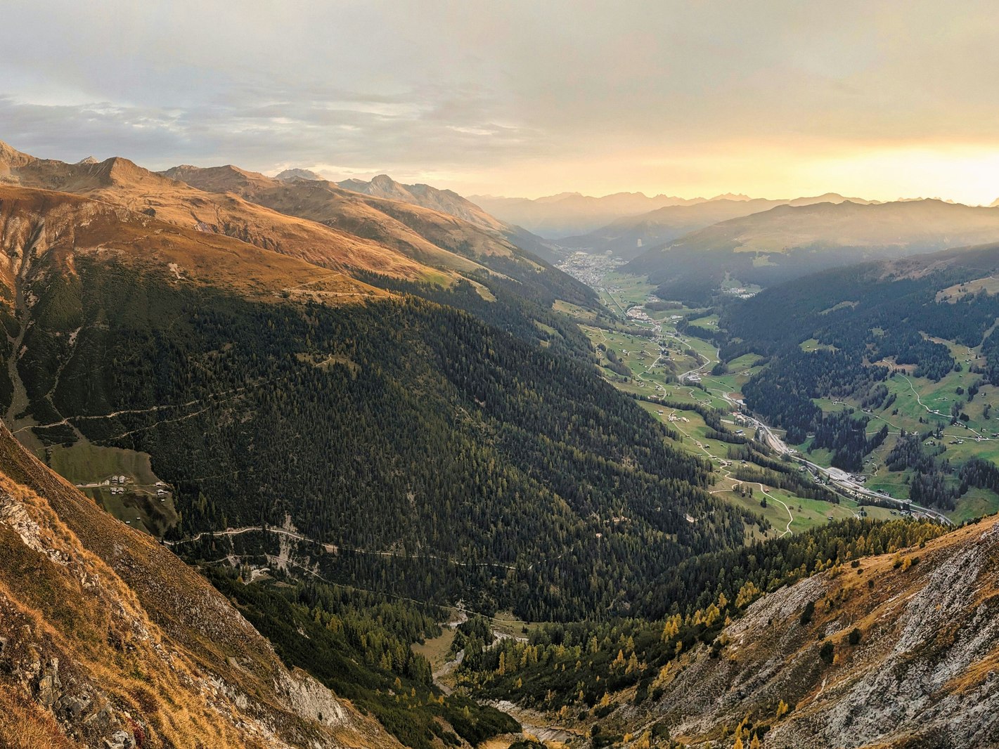 Bergpanorama Lenzerheide Bergtal in warmem Abendlicht mit Nebelschwaden über den Gipfeln
