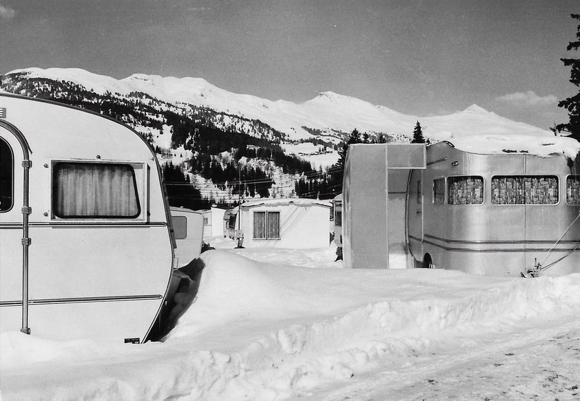 Schwarzweiss-Archivbild von schneebedeckten Wohnwagen im Winter