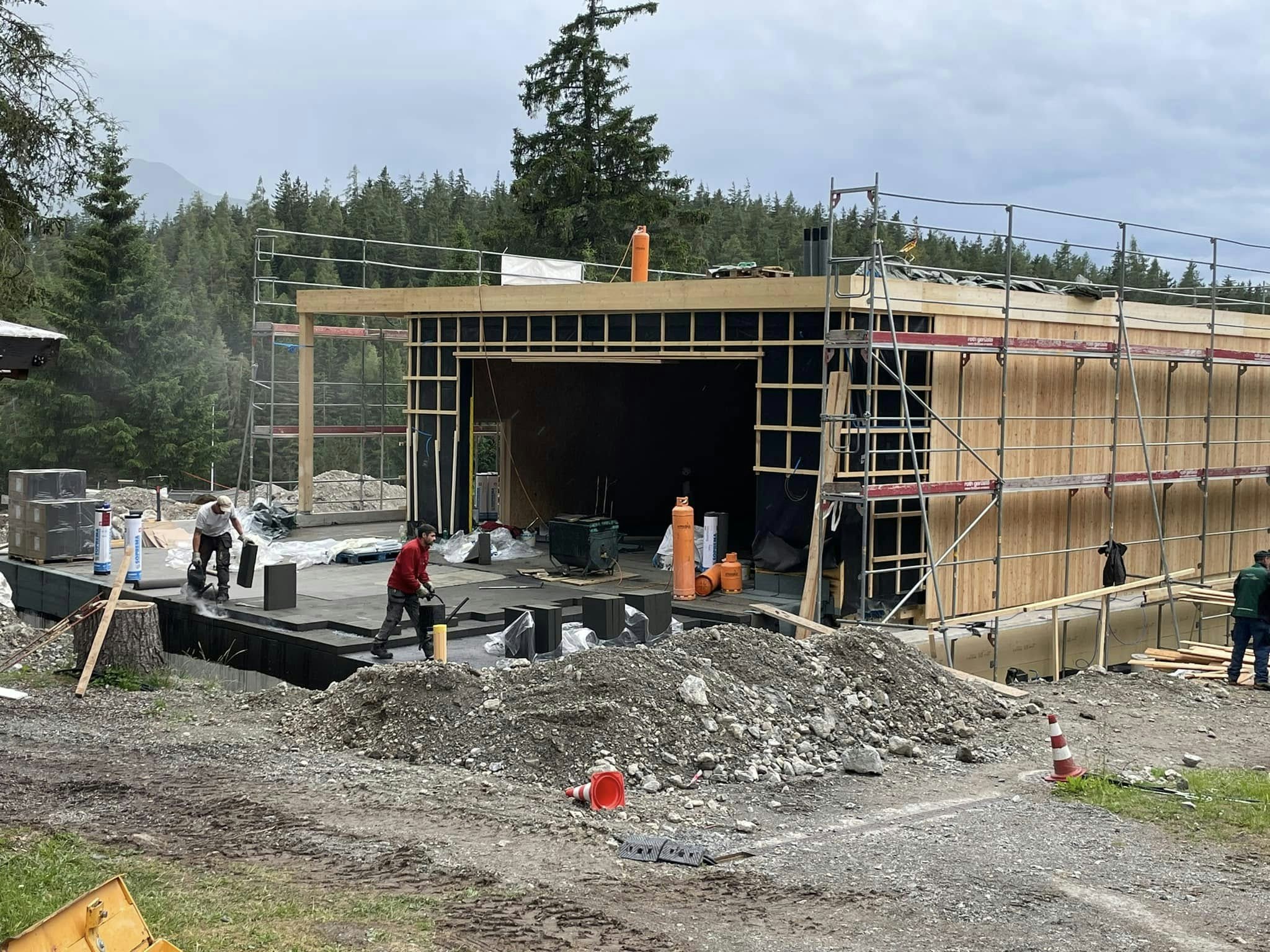 Baustelle mit im Bau befindlichem Holzchalet und Baumaterial