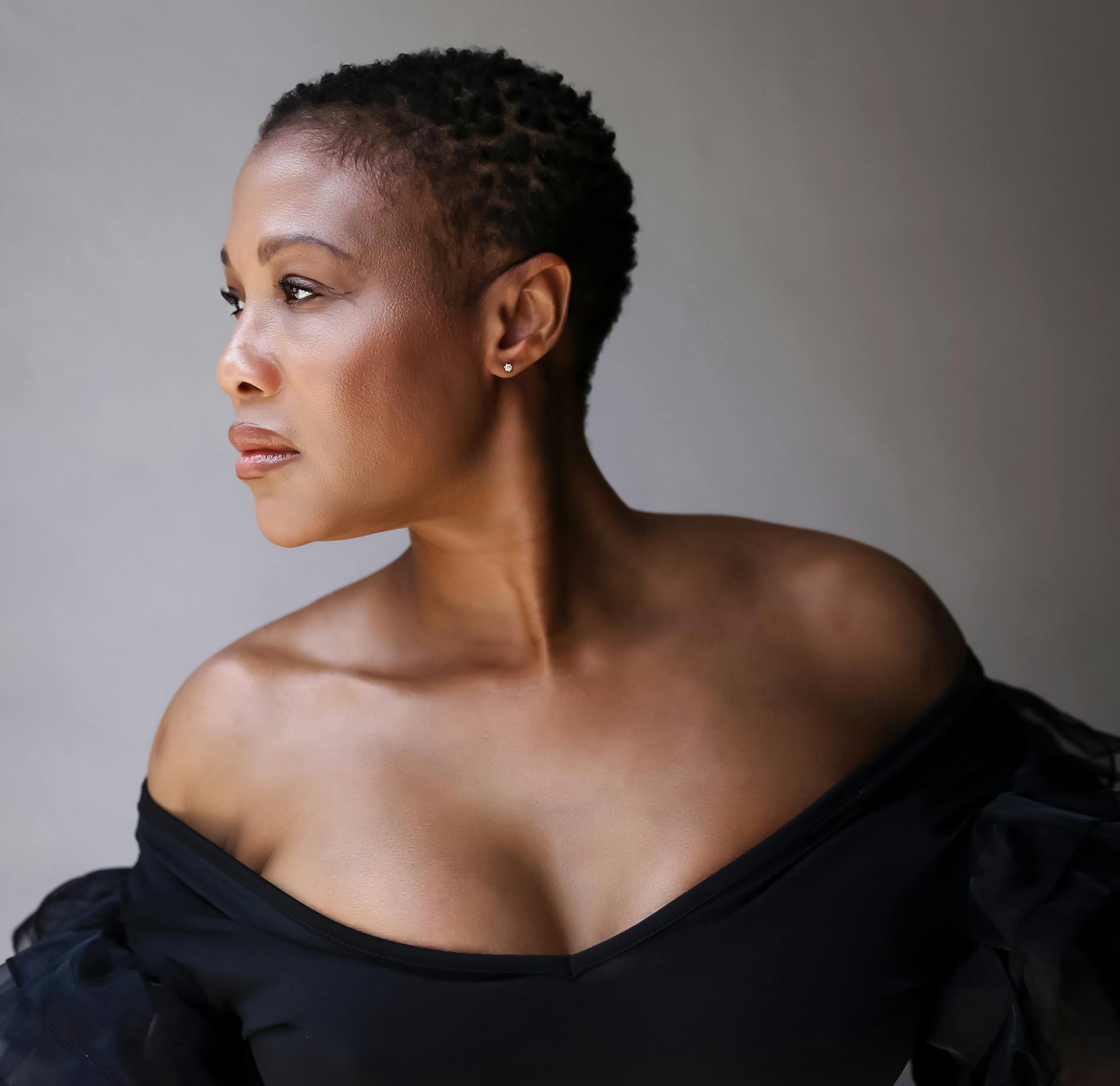 close up of a woman with a black dress posing for a picture