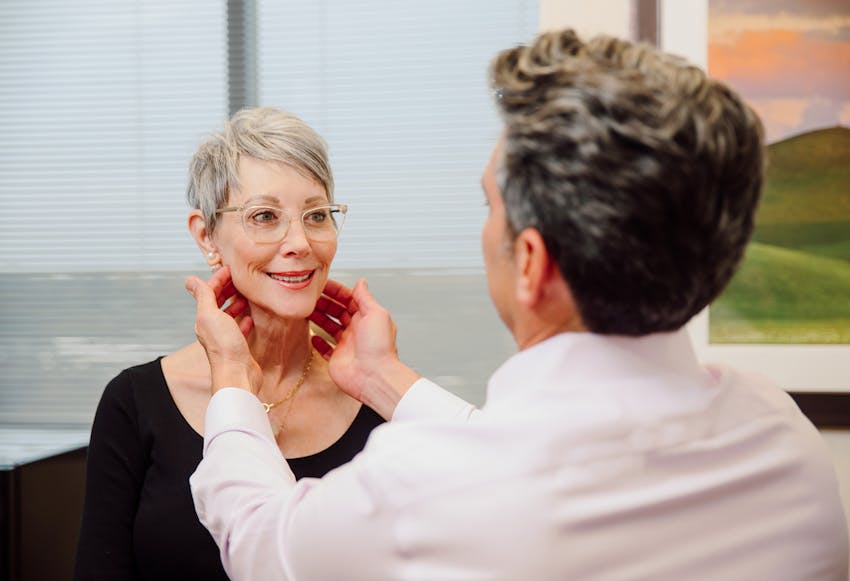 Woman getting her face examined by a doctor