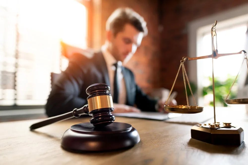 Lawyer at Desk Closeup of gavel with lawyer on background