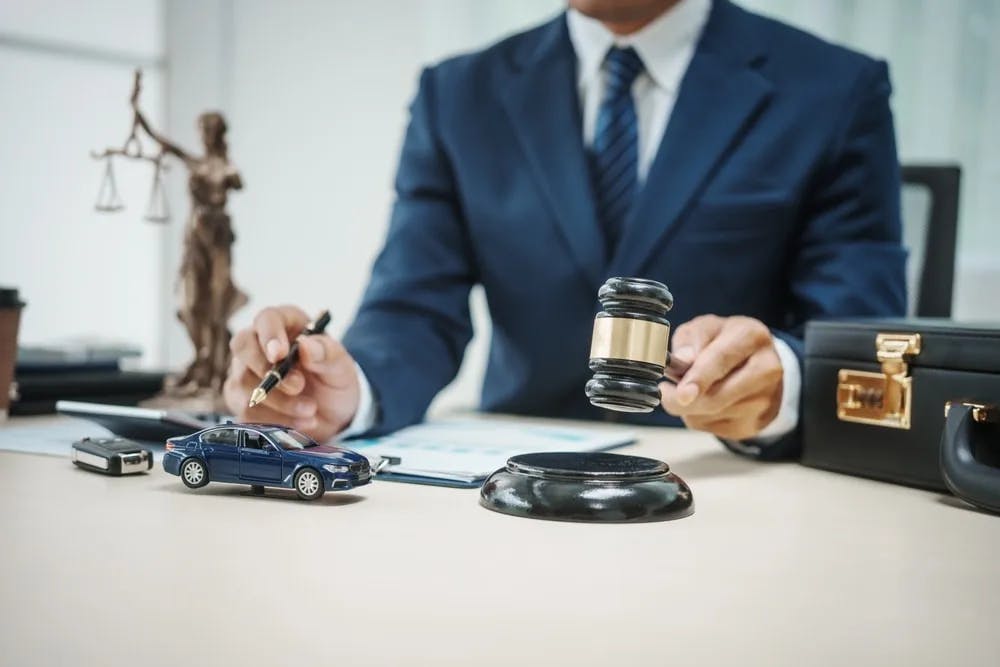 Car Accident Lawyer Car accident lawyer with a gavel in hand overlooking documents