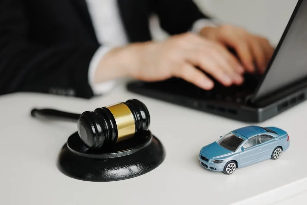 Car Accident Attorney Desk Car accident attorney working on a laptop beside a gavel and a small toy car