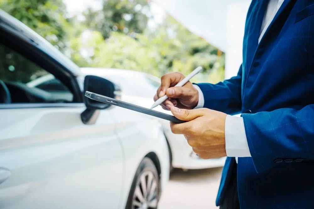Professional assessing vehicle Professional assessing vehicle's worth after an accident