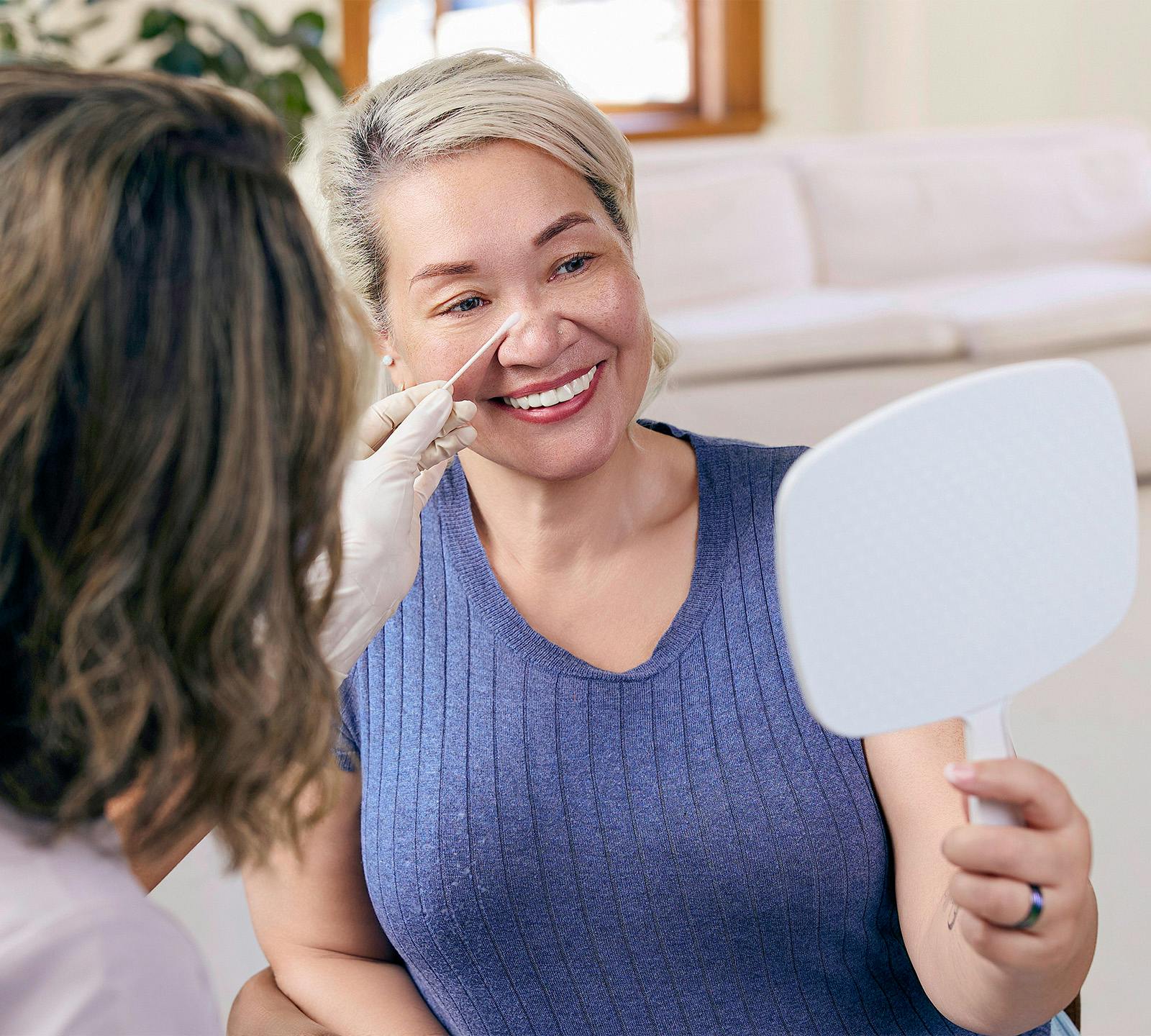 woman smiling looking in mirror