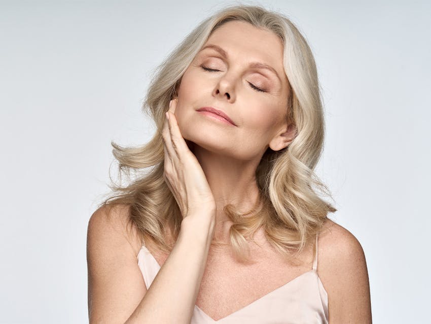 Woman touching her face with her eyes closed