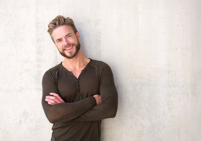 man smiling with arms crossed