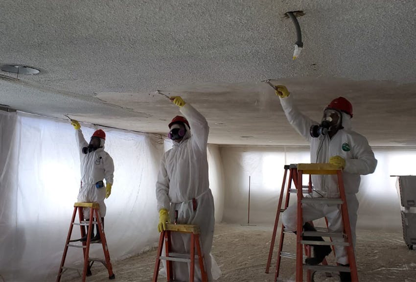 Workers scraping a ceiling