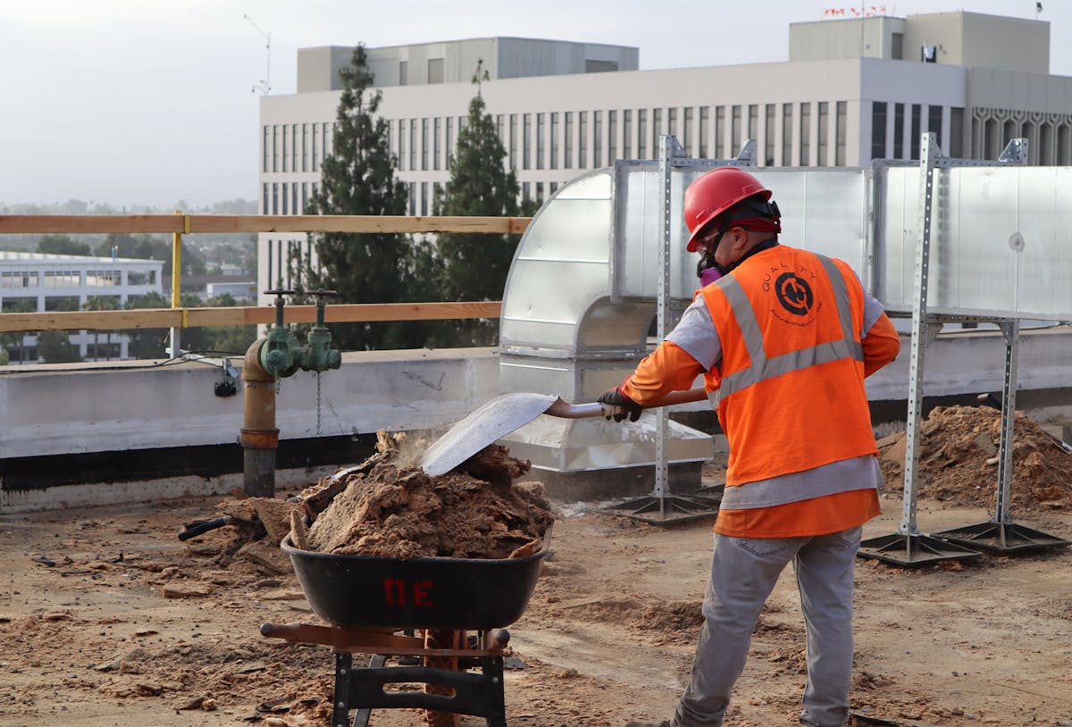 a worker shoveling debris