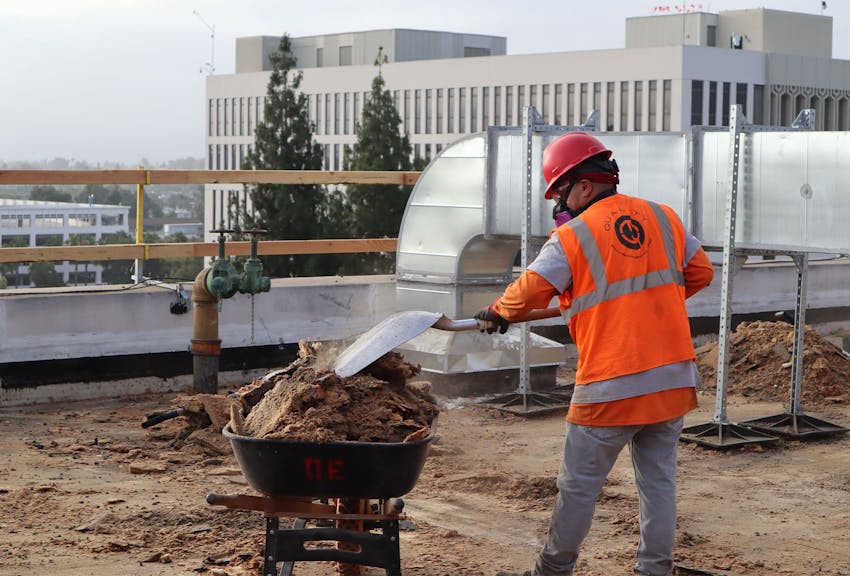 a worker shoveling debris