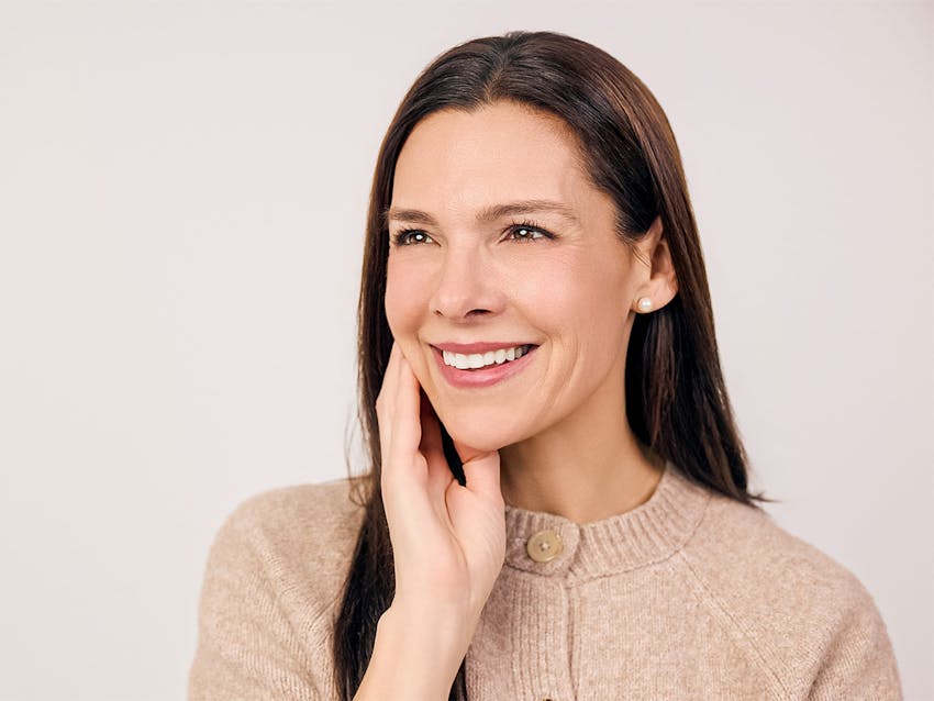 Woman smiling touching her cheek