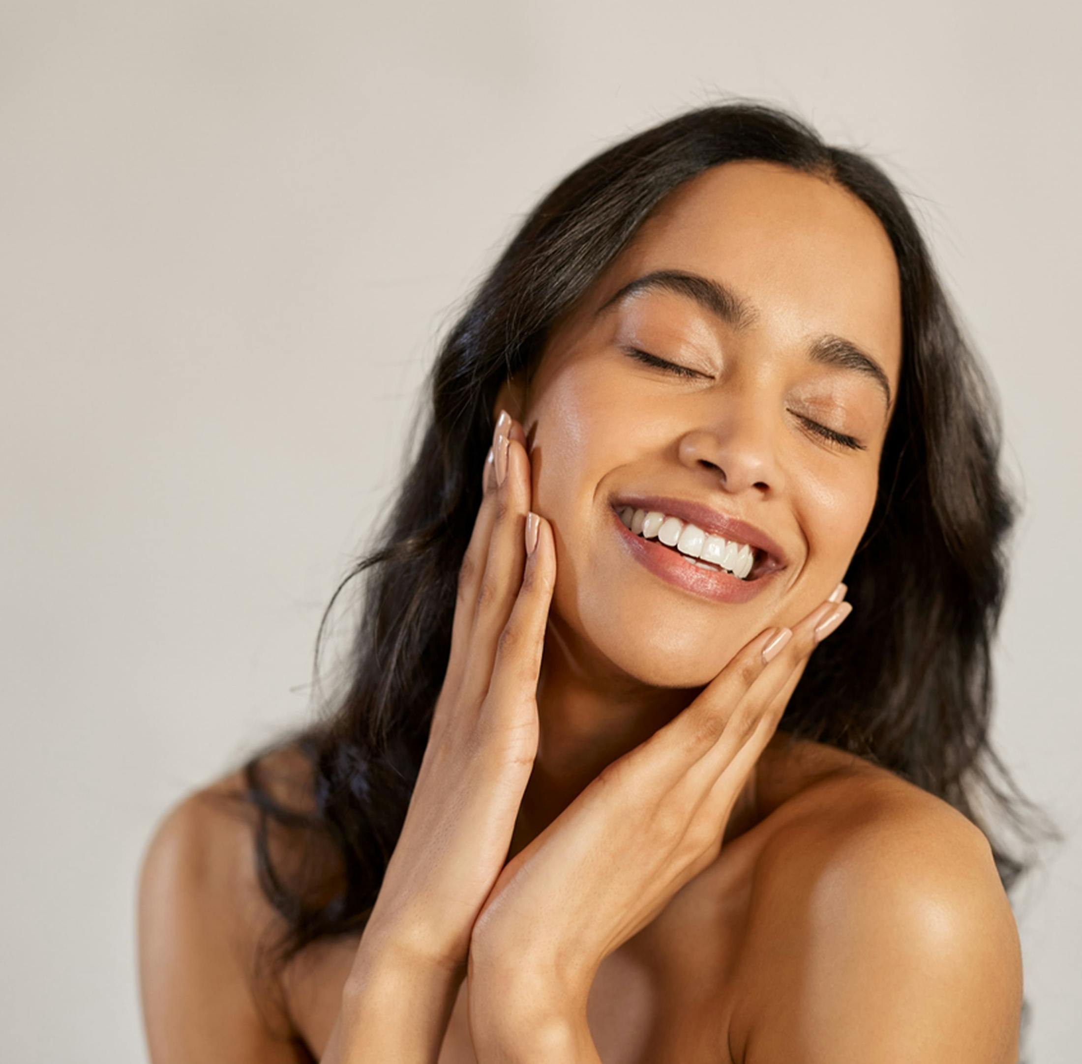 Woman smiling and touching face