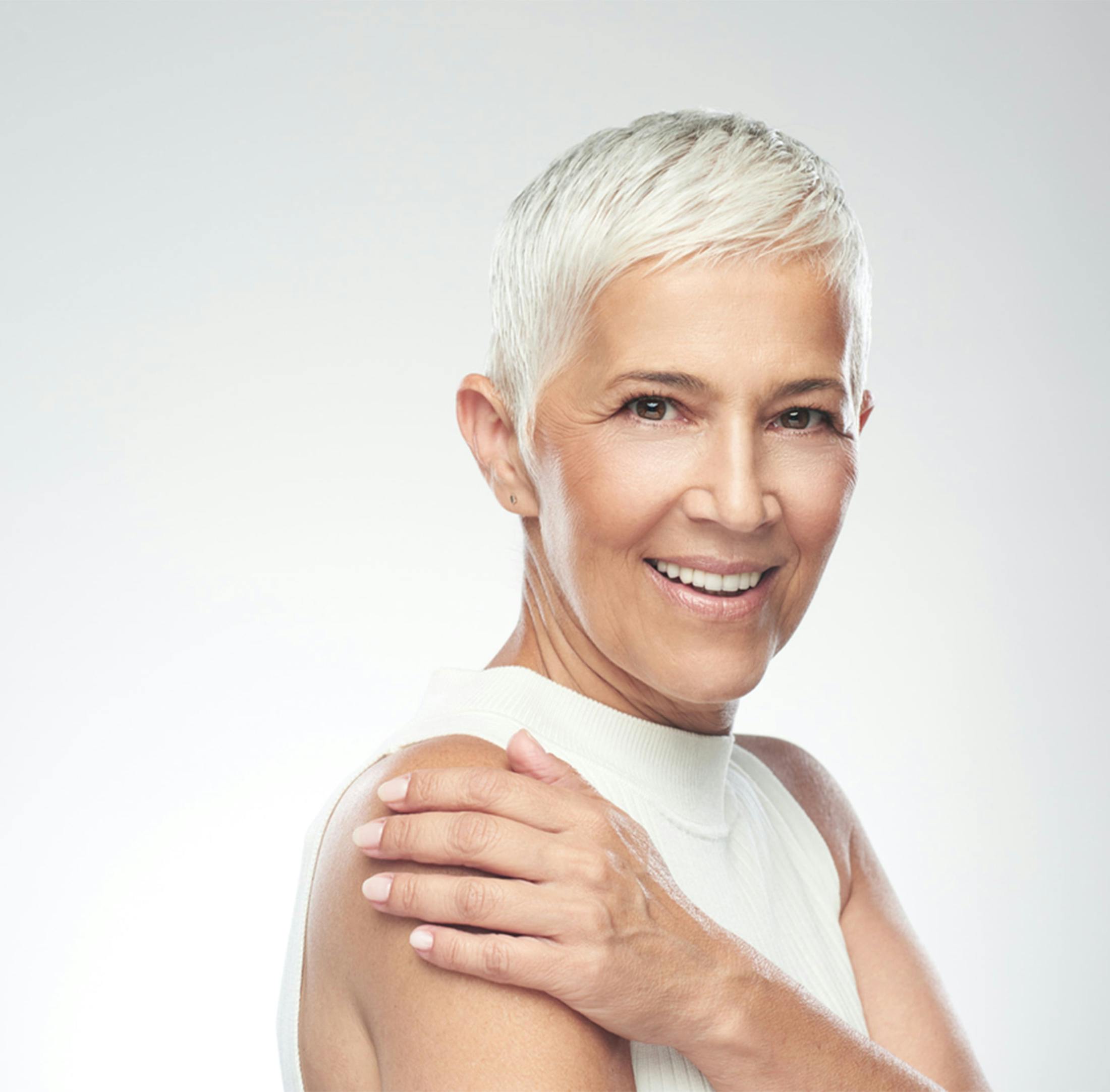 Woman smiling touching her shoulder
