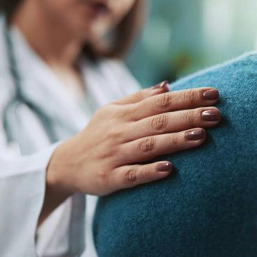 doctor with her hand on a patient's knee
