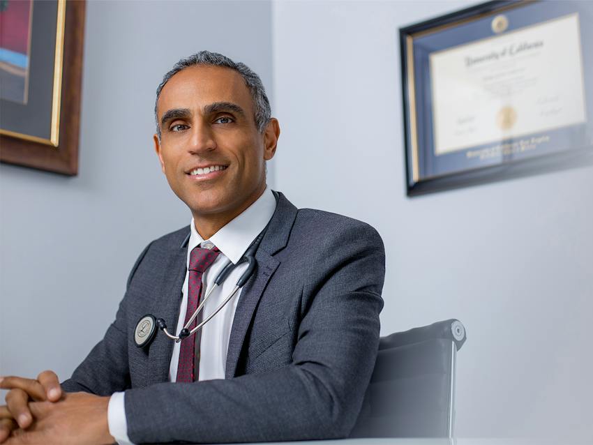 doctor sitting at desk smiling